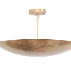 a large brass bowl hanging from a ceiling fixture