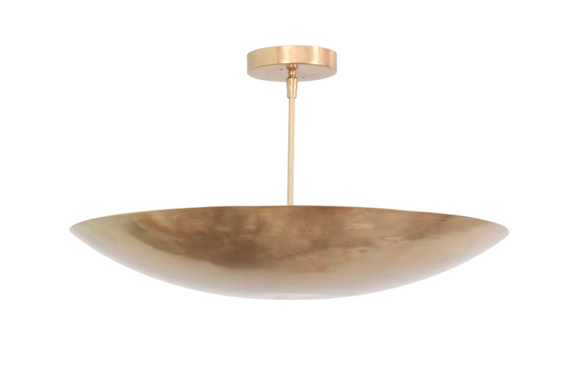 a large brass bowl hanging from a ceiling fixture