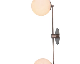 May include: A modern wall sconce with two frosted glass globes and a brushed nickel finish.