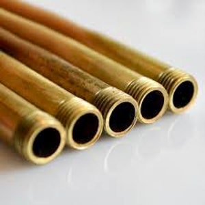 May include: Four brass pipes with threaded ends. The pipes are arranged in a row, with the threaded ends facing the viewer.
