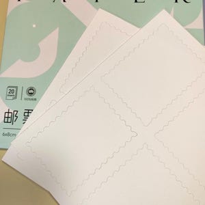 Pu&ograve; includere: Confezione di carta per acquerello con un design verde chiaro e bianco. La carta &egrave; bianca con un bordo smerlato e la confezione include il testo "WATERCOLOR PAPER" e "20 fogli". La carta misura 6x8cm.