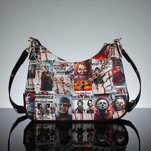 Puede incluir: Bolso de hombro blanco y rojo con un diseño de personajes de películas de terror y recortes de periódicos. El bolso tiene una correa negra y un acento de cadena dorada. El diseño incluye imágenes de Chucky y Freddy Krueger.