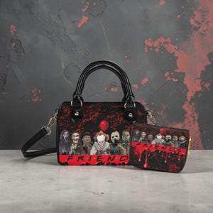 Op de afbeelding: Een zwarte handtas en bijpassende portemonnee set met een horrorthema. De tas heeft een rode ballon en een groep horrorpersonages. Het woord "FRIENDS" is geschreven in rood druipend bloed.