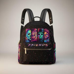 Puede incluir: Mochila negra con cuatro personajes de películas de terror y la palabra "FRIENDS" en una fuente colorida. La mochila tiene correas negras, una cremallera dorada y un diseño moteado.
