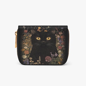 Pode incluir: Carteira preta com zíper com uma ilustração de um gato preto rodeado por flores coloridas. O gato tem olhos amarelos e está centrado na carteira. A carteira tem um zíper dourado e um fundo preto.
