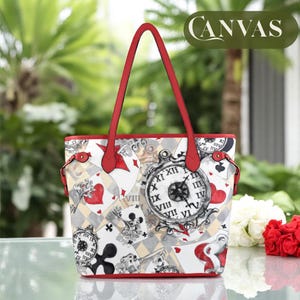 Puede incluir: Una bolsa de mano blanca con asa roja y un estampado colorido de cartas de juego, relojes y llaves. La bolsa tiene la palabra "CANVAS" impresa en la esquina superior derecha.