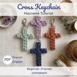 May include: Four macrame cross keychains in shades of green, purple, orange, and blue. Each cross has a silver-colored clasp. The image includes text that reads "Cross Keychain Macramé Tutorial" and "Beginner-Friendly -COTOKNOT-".