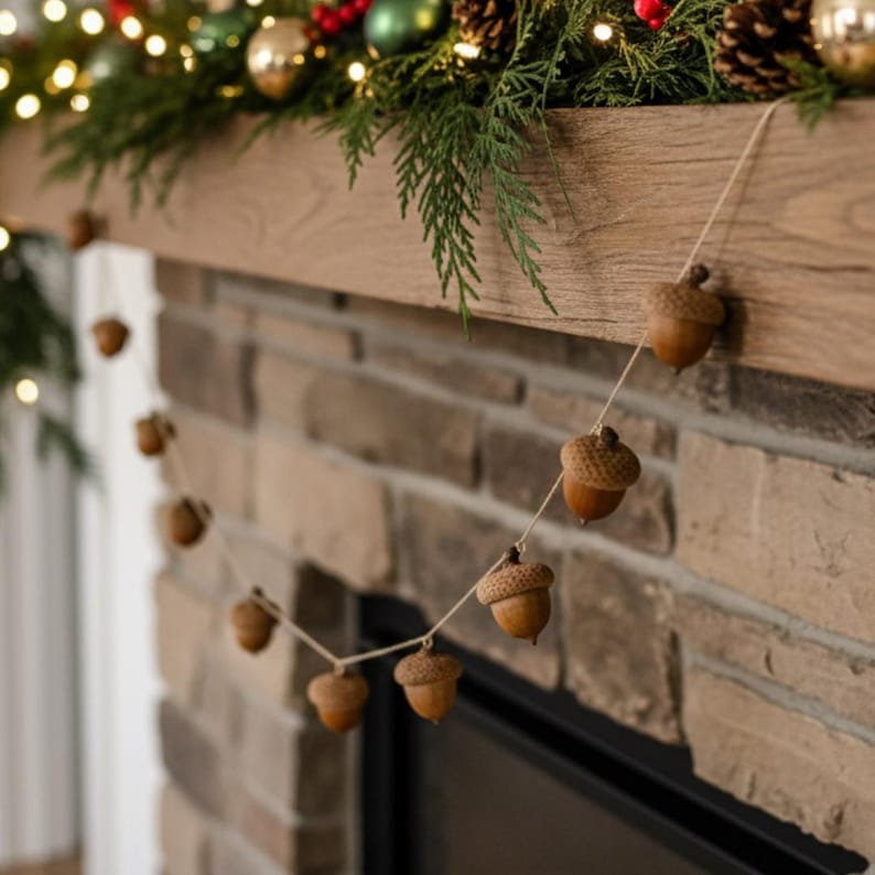 May include: A garland of brown acorns strung on twine hangs in front of a brick fireplace. The acorns are various sizes and have textured caps. The fireplace mantel is decorated with greenery, gold ornaments, and fairy lights, creating a festive holiday display.