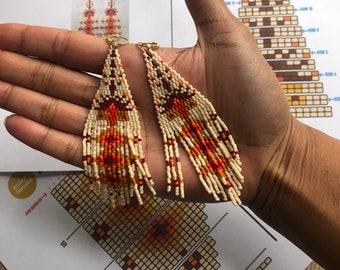 May include: A pair of beaded fringe earrings with a geometric pattern in shades of orange, brown, and white. The earrings are held in a hand, and a pattern chart for the earrings is visible in the background. The chart includes the text "Rooted Down Beaded Fringe Earrings Pattern" and "Top Section Technique: double brick stitch".