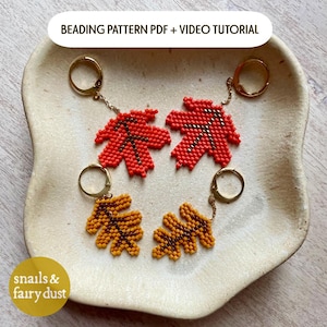May include: Two pairs of beaded leaf earrings with gold-tone hoop findings. One pair features bright red maple leaf shapes with dark brown veins, while the other pair consists of golden-yellow oak leaf shapes with dark brown veins. BEADING PATTERN PDF + VIDEO TUTORIAL.