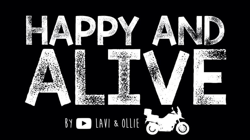 May include: White text on a black background reads "Happy and Alive" with a white motorcycle graphic below. The text "By  YouTube  Lavi & Ollie" is below the motorcycle.
