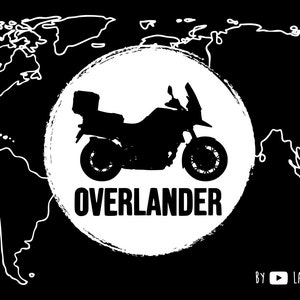 Op de afbeelding: Een zwart-witte illustratie van een motorfiets met een wereldkaart op de achtergrond. De motorfiets bevindt zich in een cirkel met het woord "Overlander" eronder. De tekst "By Lavi & Ollie" staat onderaan de afbeelding.