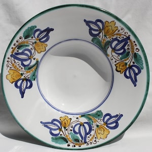 May include: A white ceramic bowl with a green rim and blue and yellow floral designs.