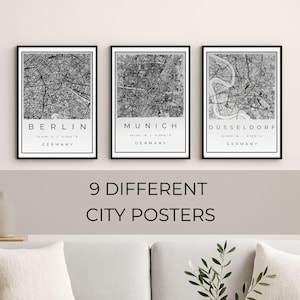 Può includere: Tre poster incorniciati di mappe della città di Berlino, Monaco e Düsseldorf, Germania, in bianco e nero. I poster sono esposti sopra un divano colorato chiaro e un tavolino di legno. Il testo "9 DIFFERENT CITY POSTERS" è sotto.