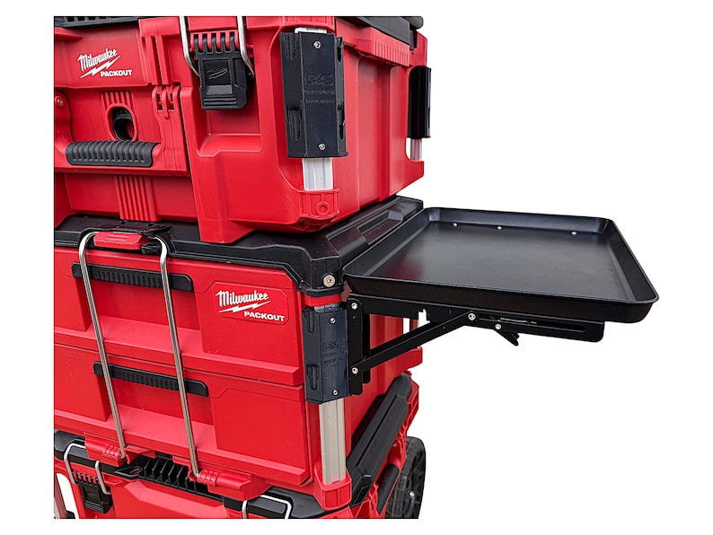May include: Red and black toolbox with a black folding work surface. The toolbox has the text "Milwaukee Packout" on the side.