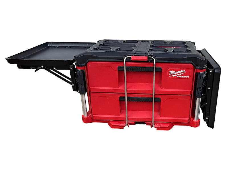 May include: A red and black Milwaukee Packout tool box with two drawers and a fold-down work surface. The tool box has a black handle and a silver latch.