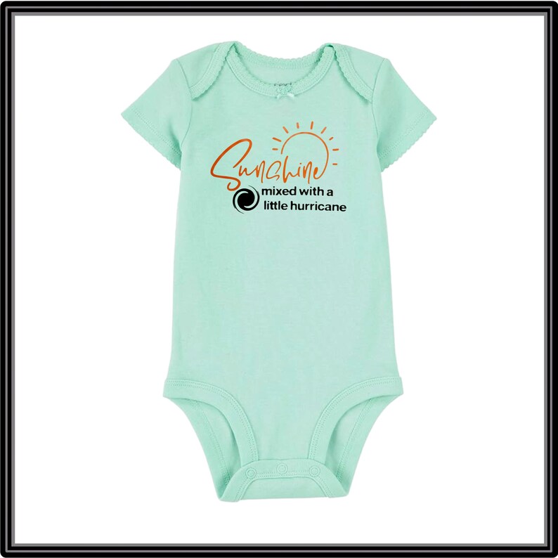 Może przedstawiać: Jasnozielone body niemowlęce z kr&oacute;tkim rękawem. Na body napisano "Sunshine mixed with a little hurricane" brązową czcionką ze słoneczkiem.