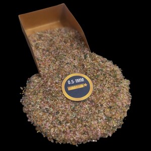 May include: A close-up of a small scoop filled with pink, green, and brown gemstone chips. The chips are approximately 0.5-1mm in size. The text "0.5-1MM" is printed on a yellow label with a ruler icon.