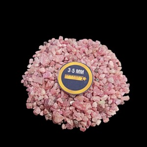 May include: A close-up of a pile of pink and red gemstone chips, measuring 3-5 mm in size. The chips are irregularly shaped and have a natural, rough texture.