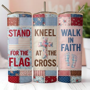 Puede incluir: Tres vasos aislados con tapas y pajitas. Cada vaso presenta un diseño de patchwork con temas patrióticos y religiosos. El texto en los vasos dice "Stand for the Flag", "Kneel at the Cross" y "Walk in Faith".