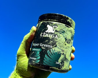 May include: A green powder supplement container with a black lid and label. The label says "Chaga Super Greens Unflavored 30 servings 240g". A monkey logo is on the label.