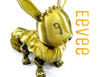 May include: A golden-colored 3D-printed Eevee figure. The figure has large ears, a fluffy tail, and detailed features. The word "Eevee" is printed vertically in orange on the right side of the image. The figure is posed on a white background.
