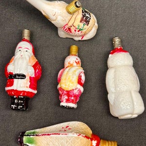 CINQUE (5) lampadine di Natale vintage in vetro di latte - (Giappone) - (Circa anni '30 / '40) Elefante, pupazzo di neve, lanterna e 2 Babbo Natale - (Non testate)