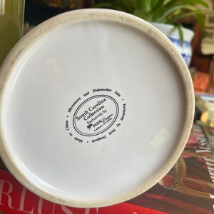 Może przedstawiać: Biały dzbanek ceramiczny z czarno-białym wzorem. Na spodzie dzbanka znajduje się etykieta z napisem "South Carolina Collection Exclusively by PARK Designs, Goldsboro, NC 27534. Made in China. Microwave and Dishwasher Safe. Exclusively by Park Designs."