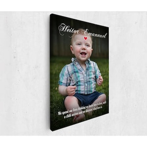 May include: A canvas print featuring a smiling baby boy in a plaid shirt and blue shorts, sitting on grass. The print includes the name "Heitor Emannuel" and a quote about love.