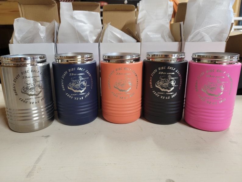 Peut inclure: Cinq gobelets isothermes en acier inoxydable avec une finition argent, bleu marine, orange, noir et rose. Chaque gobelet pr&eacute;sente un motif circulaire avec le texte "Hawaii State Disc Golf Championships 29th Annual" et un graphique d'un parcours de disc golf.
