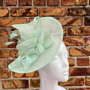 Large sinamay mint green looped fascinator with feathers