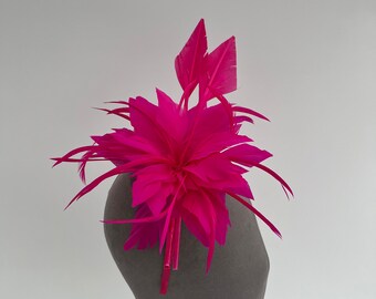 Bright Cerise Pink feather flower fascinator headband and clip sat on a feather quill base