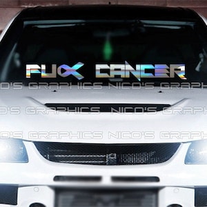 May include: A white car with a silver iridescent vinyl decal on the windshield that reads "F**K CANCER".