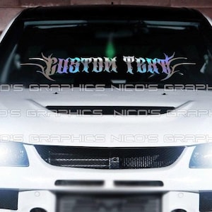 May include: A white car with a black roof and a windshield banner that reads "CUSTOM TEXT" in a stylized font. The banner has a gradient color scheme of blue, purple, and silver. The car's headlights are on.