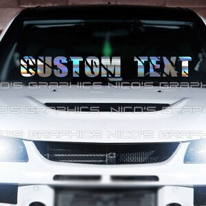 May include: A white car with a custom text decal on the windshield. The decal is iridescent and has a shattered glass effect. The text reads "CUSTOM TEXT".