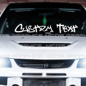 Könnte beinhalten: Weißes Auto mit einem benutzerdefinierten Text-Aufkleber auf der Windschutzscheibe, der "CUSTOM TEXT" lautet.