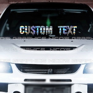 May include: A white car with a windshield decal that reads "CUSTOM TEXT" in a dripping, iridescent font. The decal is centered on the windshield. The brand name "NICO'S GRAPHICS" is repeated across the bottom of the windshield.