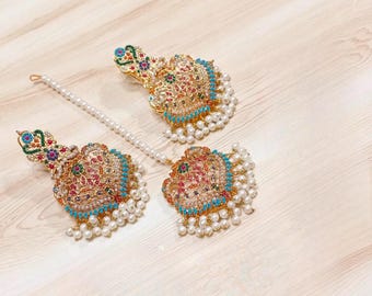 May include: A pair of gold-tone earrings featuring intricate floral designs and colourful gemstones. The earrings are embellished with white pearls and have a dangling design.