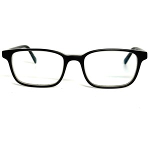 May include: Black rectangular eyeglasses with a thick frame and clear lenses. The glasses feature a bridge connecting the two rims and thin temples that extend outward. The design is simple and functional, with a glossy finish on the black plastic material.