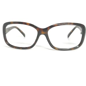 May include: Tortoiseshell eyeglasses with a dark brown frame and temples. The glasses have a classic, rectangular shape with a keyhole bridge. The lenses are clear, and the frame has a glossy finish.