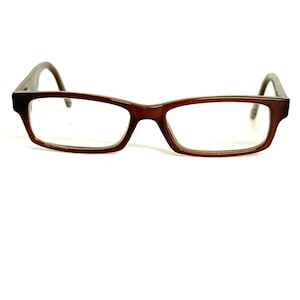 May include: Rectangular eyeglasses with a dark brown, semi-translucent plastic frame. The glasses feature clear lenses and curved temple arms that extend from the outer corners of the frame, providing a simple and functional design for vision correction.