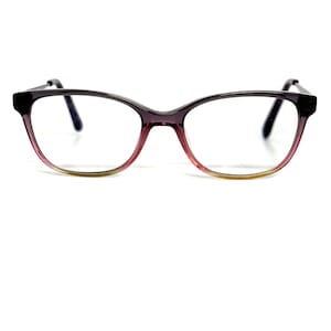 May include: A pair of eyeglasses with a cat-eye frame. The frame transitions from a dark purple at the top to a pink and then a yellow-green at the bottom. The lenses are clear.