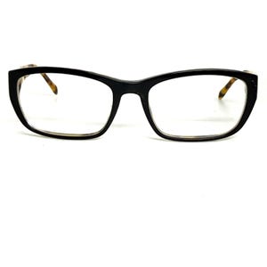 May include: Black eyeglasses with a rectangular frame and clear lenses. The temples have a tortoise shell pattern. The glasses are set against a white background.
