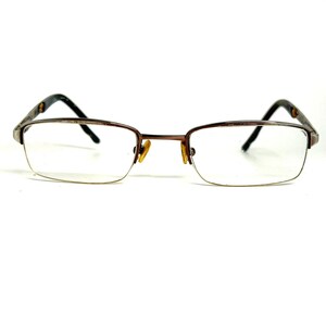May include: Semi-rimless eyeglasses featuring a metallic brown frame with rectangular lenses. The design includes adjustable nose pads and dark brown temple arms with a subtle patterned finish, providing a clear view of the front-facing structure.