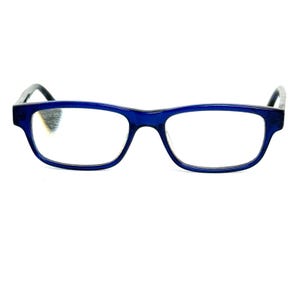 Pode incluir: Um par de óculos retangulares azuis com lentes transparentes. As armações são de um azul vibrante, e as hastes são de um tom mais escuro. Os óculos estão sobre um fundo branco.