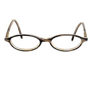 Pode incluir: Óculos ovais com um padrão listrado marrom e bege. As armações têm uma aparência sutil e texturizada, e as lentes são transparentes. As hastes dos óculos curvam-se suavemente, e o design geral é clássico e discreto.