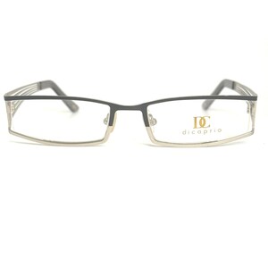 May include: Rectangular spectacles with a black and silver frame. The lenses are clear, and the temples are silver with black accents. The brand name "dicaprio" is printed in gold on the right lens.