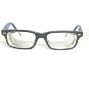 May include: Rectangular black spectacles with blue arms. The glasses have clear lenses and a dark grey frame. The arms are a bright blue colour. The spectacles are set against a white background.