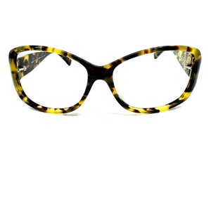 May include: Tortoise shell eyeglasses with a cat-eye shape and clear lenses.