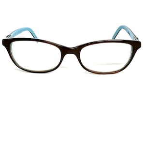 May include: Brown eyeglasses with a cat-eye shape and light blue temples. The glasses have clear lenses and a dark brown frame. The design is a classic style, suitable for everyday wear.